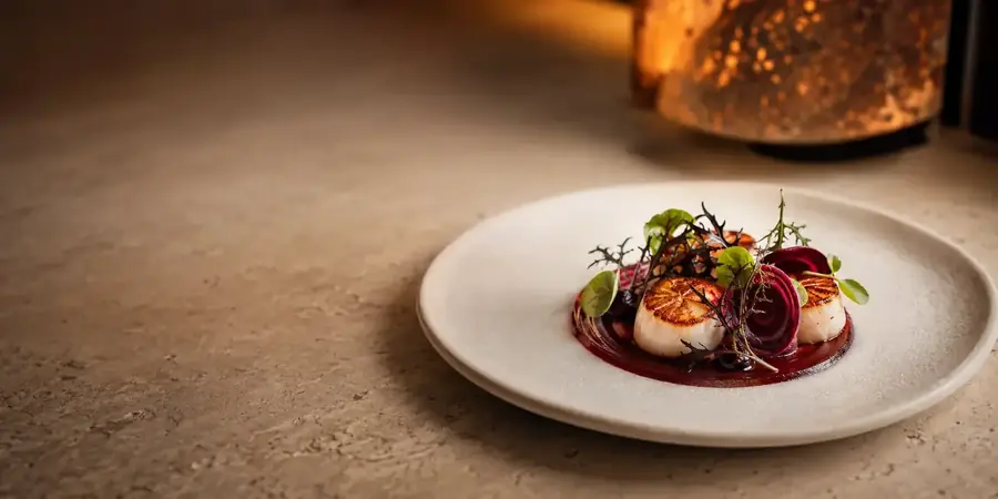Assiette gastronomique contemporaine dressée sur une table en pierre
